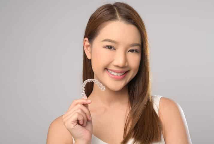 Happy patient smiling confidently while wearing Invisalign